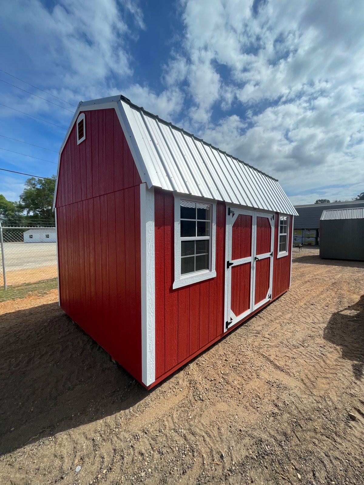 Red side lofted barn shed with white trim on the Lauderback's lot in Sneads, Florida